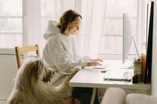 mujer joven junto a su perro escribiendo un poema de perros